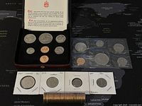 Photo showing a 1977 Canadian uncirculated coin set in case, 1983 proof-like coin set in case, roll of pennies, and assorted loose coins in flips and plastic sleeves.