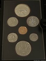 Front view of the coin set showing six silver coins and one copper-colored coin housed in display case.