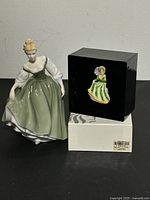 Photo showing the figurine and its original box on a black surface.