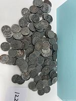 Photo showing many 1943 USA steel pennies spread out on a surface with some oxidation and wear visible on coins.