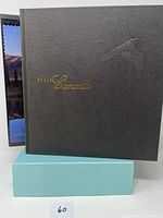 Black hardcover album with gold embossed 'Collins Canada' text and bird design, showing front cover.