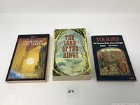 Photo showing three paperback Tolkien books: The Book of Lost Tales, The Lord of the Rings, and a collection including Sir Gawain & the Green Knight.
