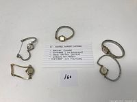 Photo showing five vintage women's watches arranged around a handwritten note listing brands and features.