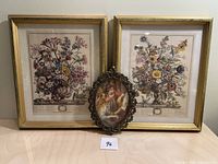 Lot overview showing two gold-framed floral prints behind a small oval miniature portrait on table, composition clear