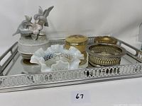 Photo of the full metal glass dresser tray with assorted decorative items on it.