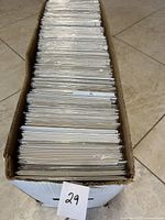 Box filled with comics in plastic sleeves, showing the quantity and condition of the comics.