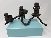 Front angle showing the full three-armed brass monkey candelabra with each monkey holding a candle holder.