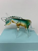 Side view of Murano style glass donkey figurine showcasing colored body and clear glass legs and ears
