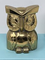 Front view of solid brass owl coin holder showing detailed face and body