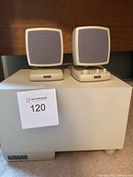 Front view of two vintage Altec Lansing satellite speakers on a subwoofer.