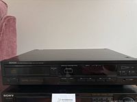 Front view of Denon DCD-600 CD player showing display, digital audio logo, and control buttons.