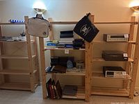 Three wooden shelving units shown in a basement setting with various items on shelves (contents not included in sale).