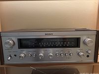 Front panel of receiver showing Sony logo, analog FM/AM tuner scale, volume, balance, tone and function controls