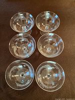 Top down view of 6 etched champagne/sherbet glasses showing wheat pattern etching on bowls.