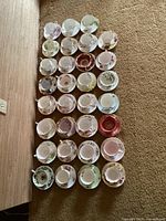 Top-down view of all 31 teacup and saucer sets arranged in rows on carpet