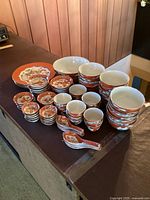 Overhead shot of entire set displayed on dark surface showing all bowls, plates, saucers and spoons in dragon and phoenix pattern