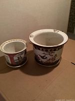 Photo showing set of two vintage Chinese porcelain flower pots with traditional hand-painted floral and bird designs, seen from above.