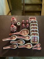 Image showing all items in the set arranged on a dark surface in an overhead view, displaying salt and pepper shakers, soy bottles, dual sauce dishes, soup spoons, and serving spoons.