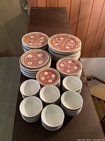 Overhead view of stacked plates and rice bowls on a dark surface