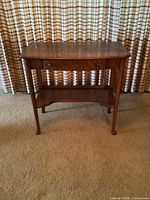 Front-facing view of the vintage oak hallway table showing the single drawer closed and the lower shelf.