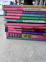 Photo showing 12 children's books stacked, including 11 Dear Dumb Diary books by Benton and one additional journal book.