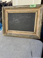 Front view of a rectangular blackboard in a worn vintage wood frame with a gold decorative inner border, showing dimensions approx. 16 1/4 by 12 1/4 inches.