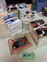 Multiple stacks of basketball cards in good condition on a workbench, with various player images visible on top cards