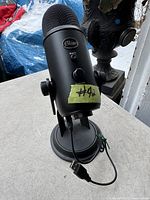 Front view of Blue Yeti microphone showing mute button, volume knob, and USB cable attached