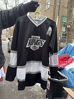 Front view of black NHL Los Angeles Kings hockey jersey with team logo and 'A' patch.