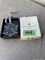 Clear crystal snowflake ornament displayed in original white Royal Doulton box with branded silver ribbon inside box, box marked #28