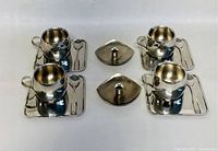 Set of 4 espresso cups on rectangular saucers with spoons, and 2 separate candleholders shown from top view.