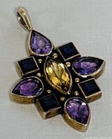 Front angle view of the sterling silver pendant showing the amethyst, citrine, and iolite crystals with minor wear.