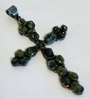 Front view of the silver cross pendant featuring dark green tumbled quartz stones.