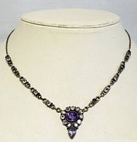 Front view of the necklace on a display bust showing the amethyst and green quartz stones and silver chain.