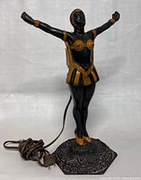 Front view of the Art Deco metal lady dancer lamp showing full figure, ornate base, and electric cord.
