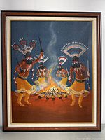 Full view of the framed painting showing four Native American figures dancing around a fire at night, capturing the entire artwork and frame.
