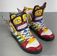 Front view of pair showing multi-color leather upper and totem mask tongue design