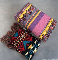 Photo showing folded Yorkshire Rose Quilters Guild blanket and a Pendleton scarf with Native American geometric pattern and fringes
