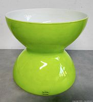 Front view of lime green hourglass-shaped vase with Anne Nilsson label on base.