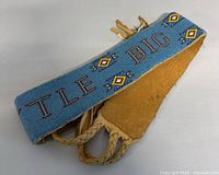 Belt folded showing the text and beadwork details with leather end visible
