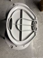 Top view of the underside of the foldable bath chair showing plastic construction and hinge mechanism.