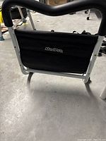 Side view of MedPro bed rail showing black fabric panel with brand label, metal frame, and foam handle.