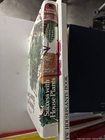 Side view of the book titled 'Success with House Plants' showing spine and partial front cover with plant images and title.
