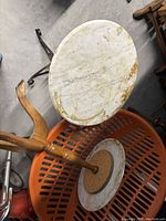 Top view showing oval white marble top with natural veining and discoloration