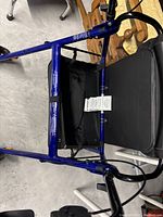 Top-down view of blue metal frame walker showing padded black seat and storage compartment underneath.