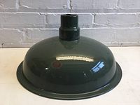 Metal hunter green enamel lamp shade with dome shape and narrow neck, placed upright showing dome surface and mounting opening.