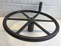 Side perspective view of large metal wheel showing six spokes and central mounting hub.