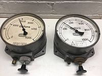 Front view of pair of Ontos gallons gauges, one measuring up to 5000 gallons, the other up to 1000 gallons.