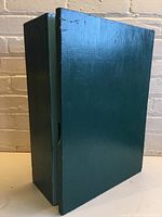 Angled image of green painted wooden cabinet box showing front and side.