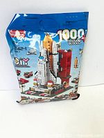 Front view of the sealed 1000 pcs blocks bag showing the space shuttle and related accessories image on the packaging
